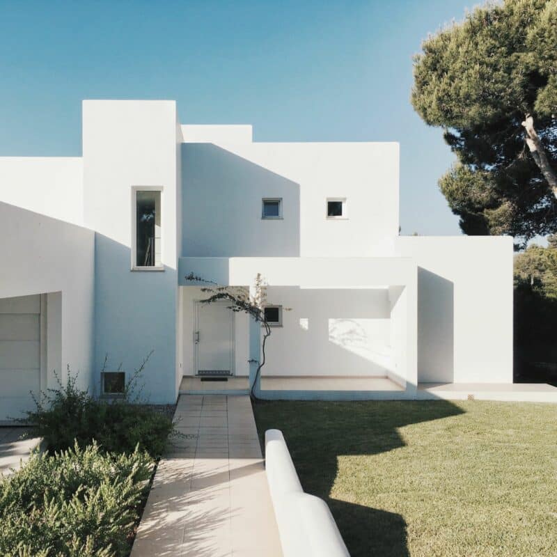 Casa blanca minimalista entre árboles — imagen provisional